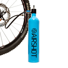 Airshot tubeless tire inflator, a blue air cylinder, connected by its hose to a mountain bike wheel