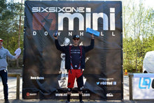 A rider on a downhill race podium holds up an Airshot