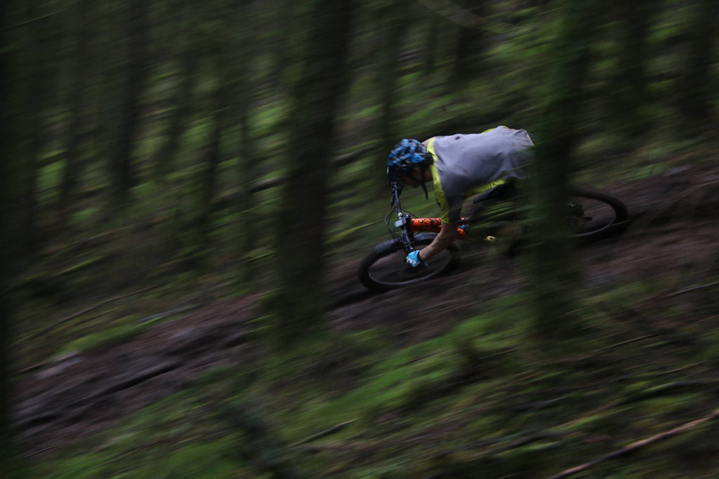 Mountain biker riding fast down a forest trail