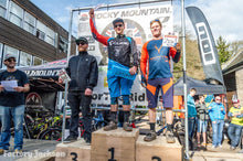 Three riders on a race podium, the winner holding an Airshot box