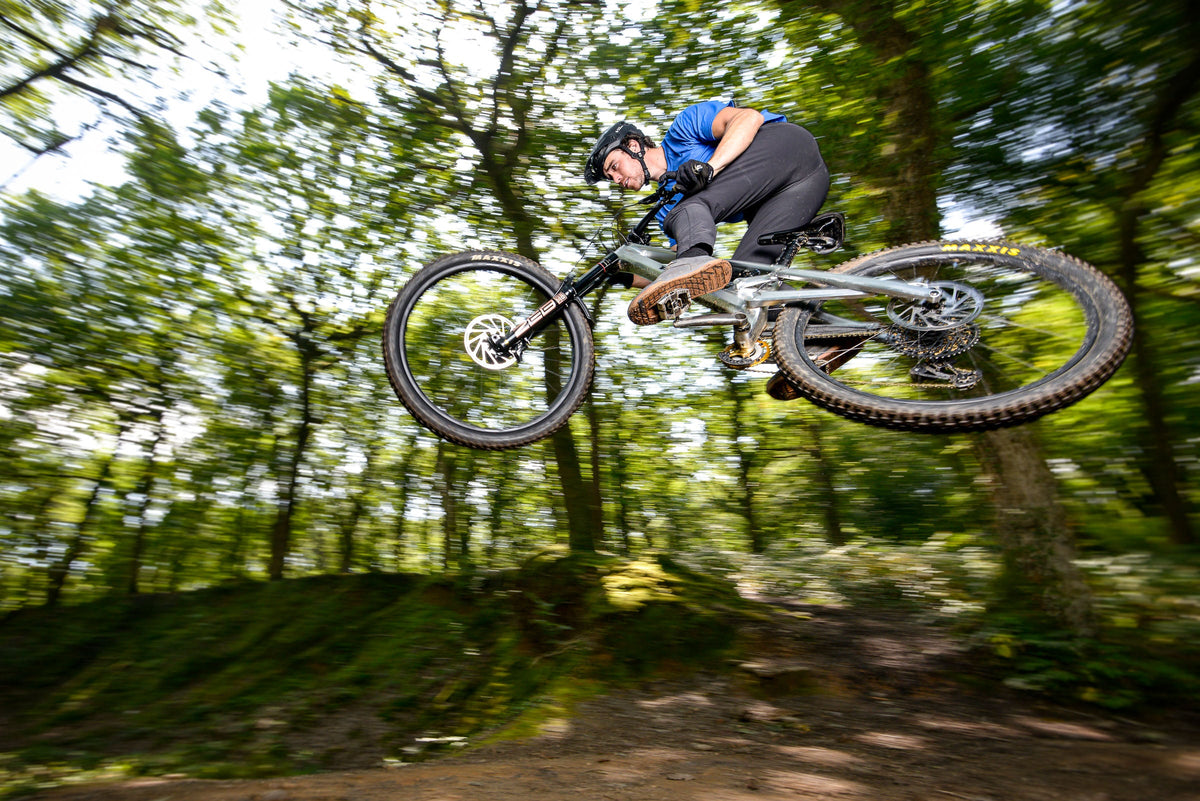 Mountain biker in the air on a forest trail